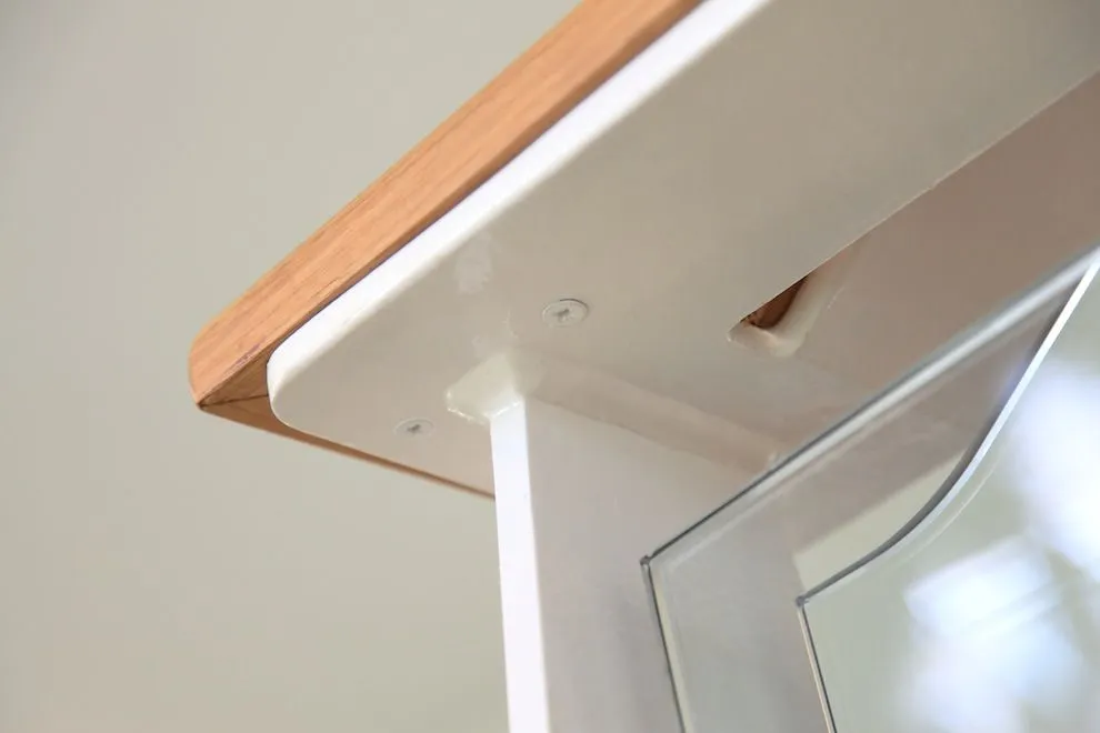 Close-up of an oak handrail on a white steel stair stringer with glass balustrade