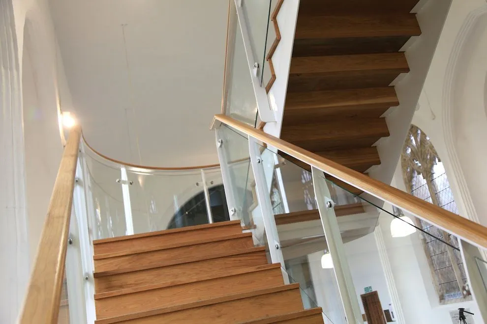 Looking up the oak-tread staircase with oak handrail and glass balustrade in St Michael's Church