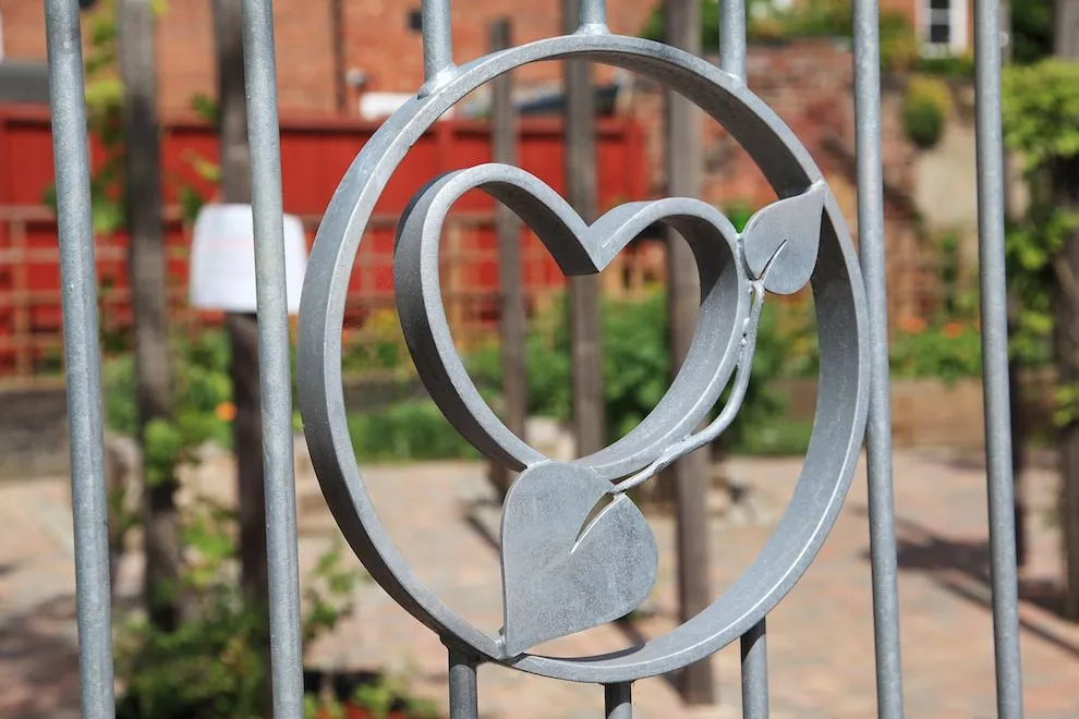 Galvanised steel gate panel with a heart-and-leaf motif at Grapes Hill Community Garden