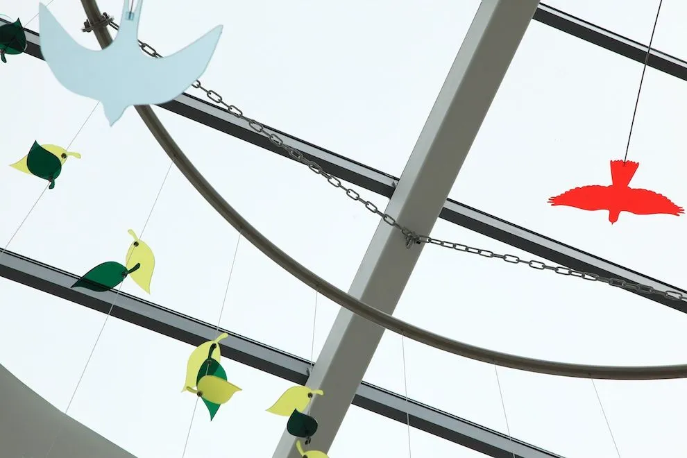 Hanging artwork of coloured steel birds and leaves suspended from rods