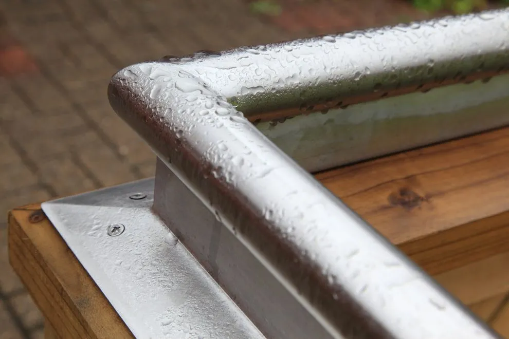 Stainless steel capping rail on the corner of a timber raised bed