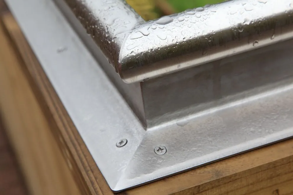Folded stainless steel capping on a timber raised-bed corner