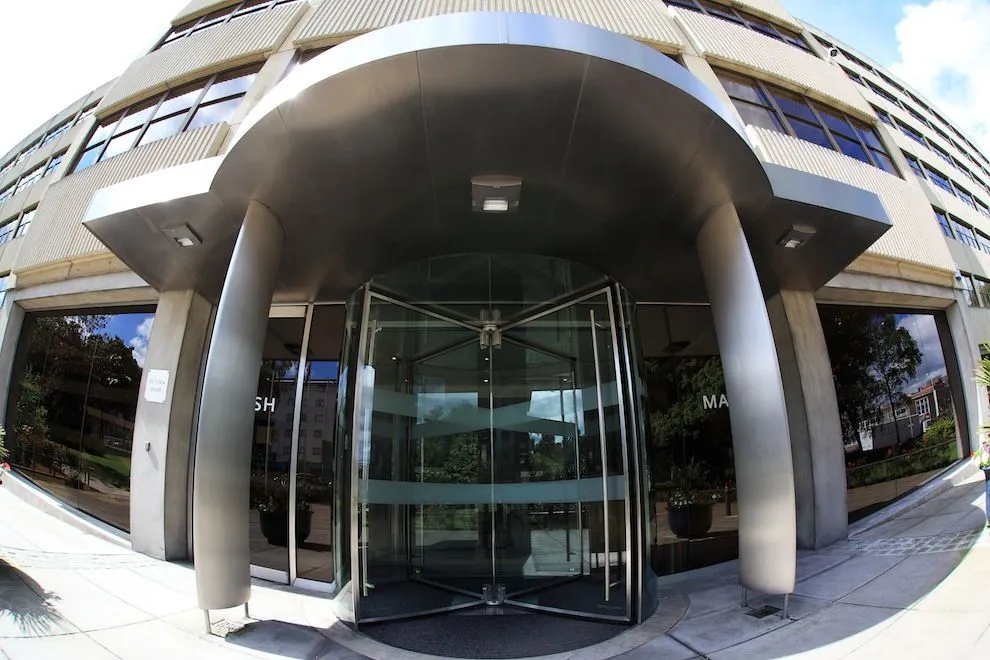 Curved stainless steel entrance canopy over revolving doors