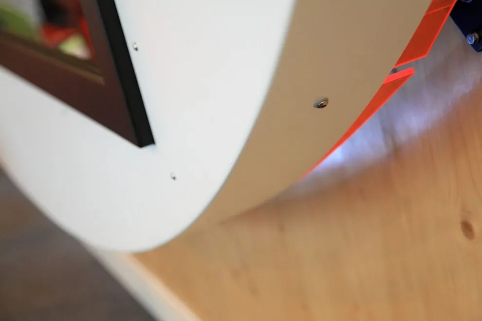 Curved white aluminium TV surround fixed to a timber wall
