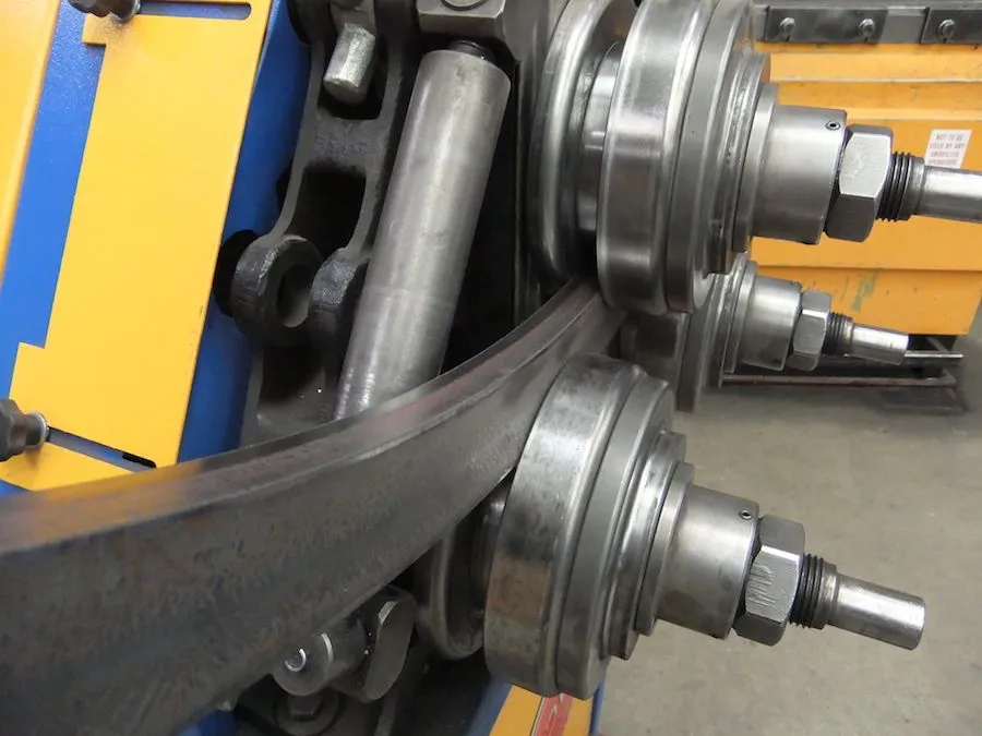 Steel bar being rolled into a curve on a section-rolling machine