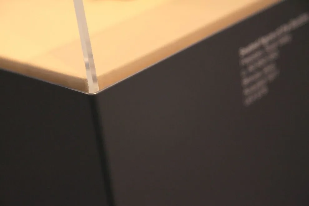 Dark powder-coated steel display case with a clear top