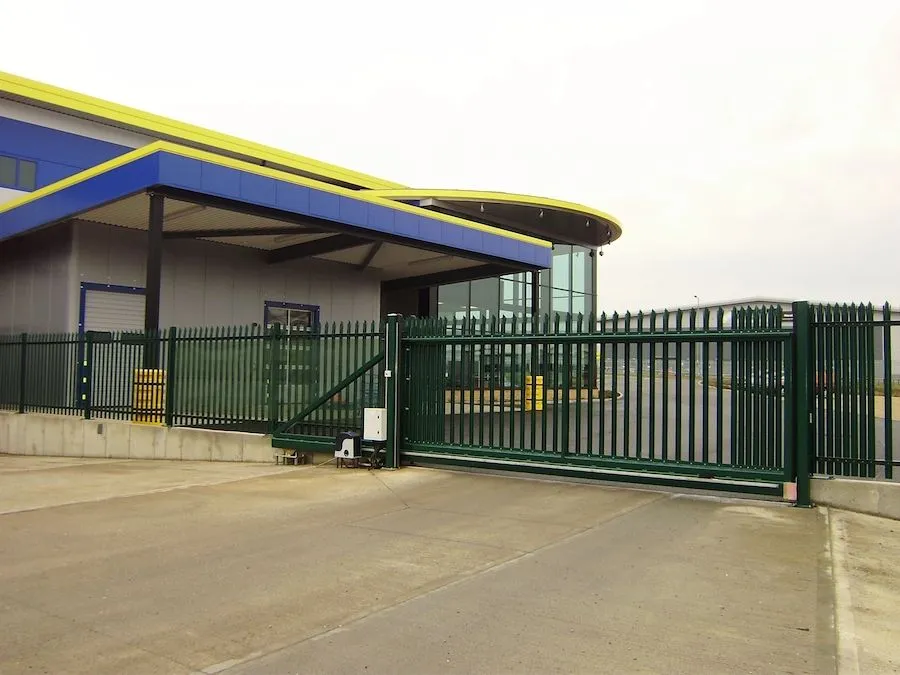 Green steel sliding security gate and fencing at a commercial unit