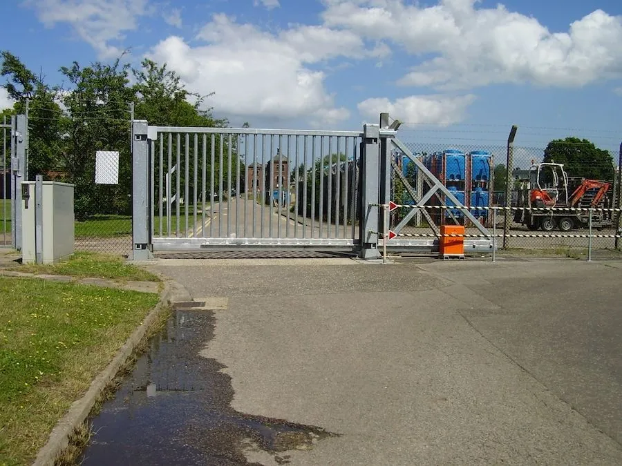 Galvanised steel sliding security gate across a site entrance