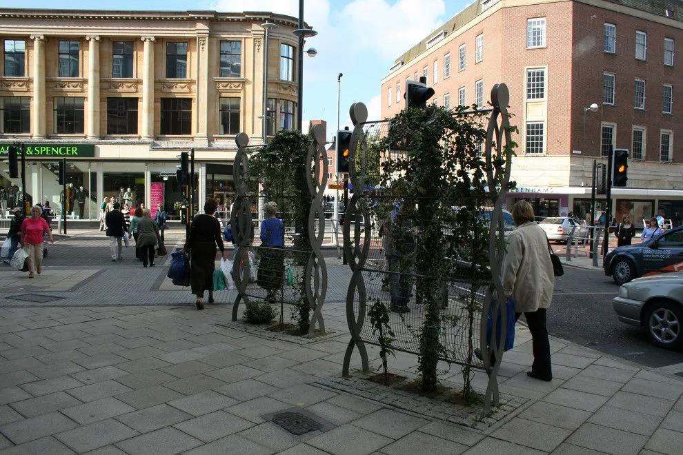 Pair of decorative steel plant supports with climbing plants on St Stephens Street
