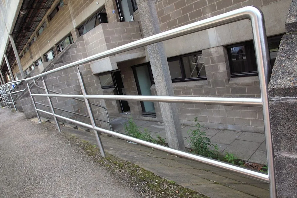 Stainless steel handrail and rails along an external walkway