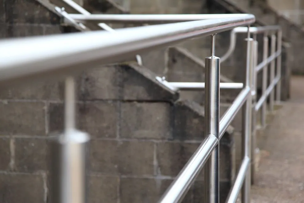 Close-up of a stainless steel handrail on a concrete walkway